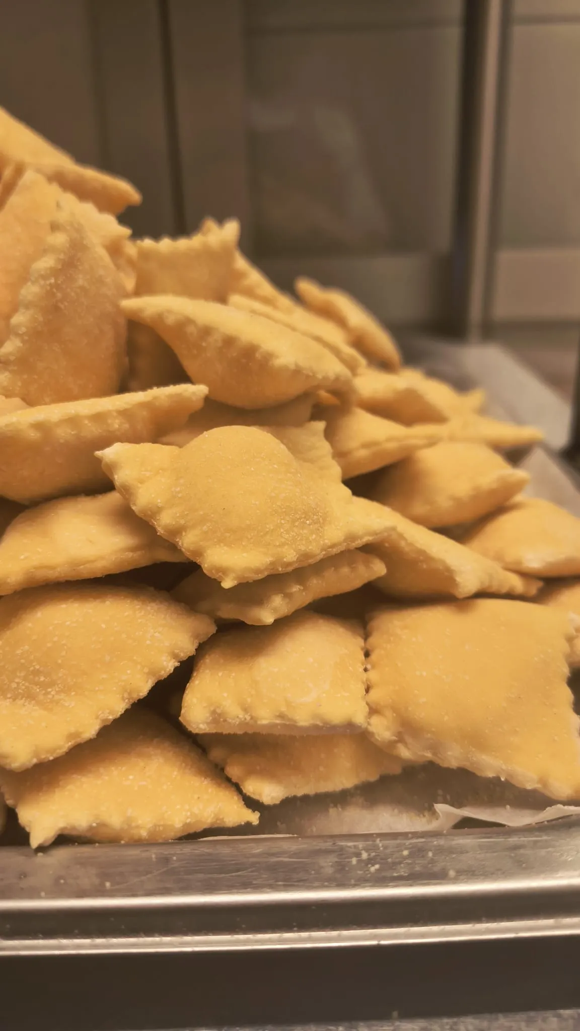 Una pila di ravioli freschi su un vassoio Una pila di ravioli freschi su un vassoio