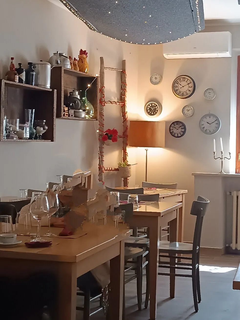 I tavoli in legno della sala, con la luce calda di una lampada I tavoli in legno della sala, con la luce calda di una lampada