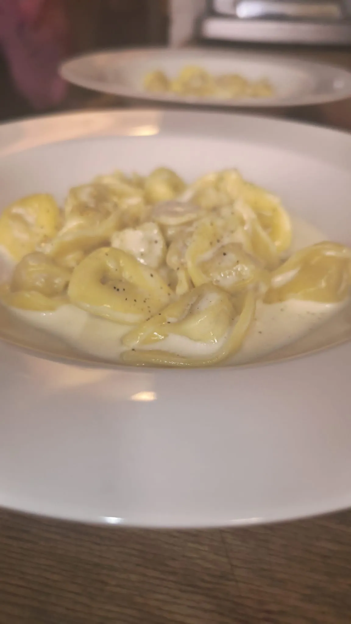 Tortelli in un piatto bianco su un tavolo di legno Tortelli in un piatto bianco su un tavolo di legno